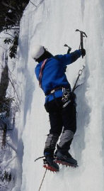 Man climbing snow covered cliff